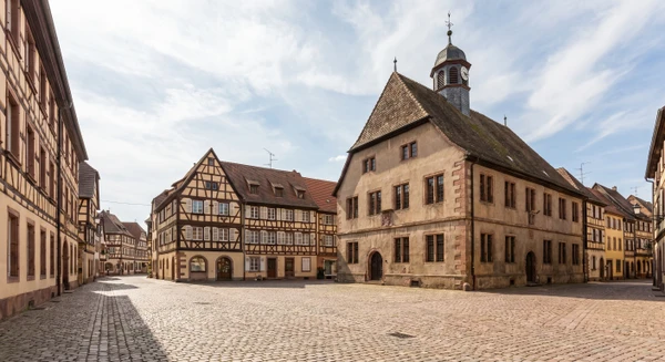 Une photographie réaliste et professionnelle montrant une vue caractéristique de Sarre-Union, commune du Bas-Rhin. La scène doit représenter un élément emblématique ou représentatif de la localité : son centre-ville, une rue principale avec commerces et bâtiments locaux, une perspective urbaine typique, un bâtiment administratif ou culturel reconnaissable de la commune, prise en bon éclairage naturel, sans texte, logo ou filigrane visible. La qualité doit être professionnelle et appropriée pour un site de constructeur immobilier.