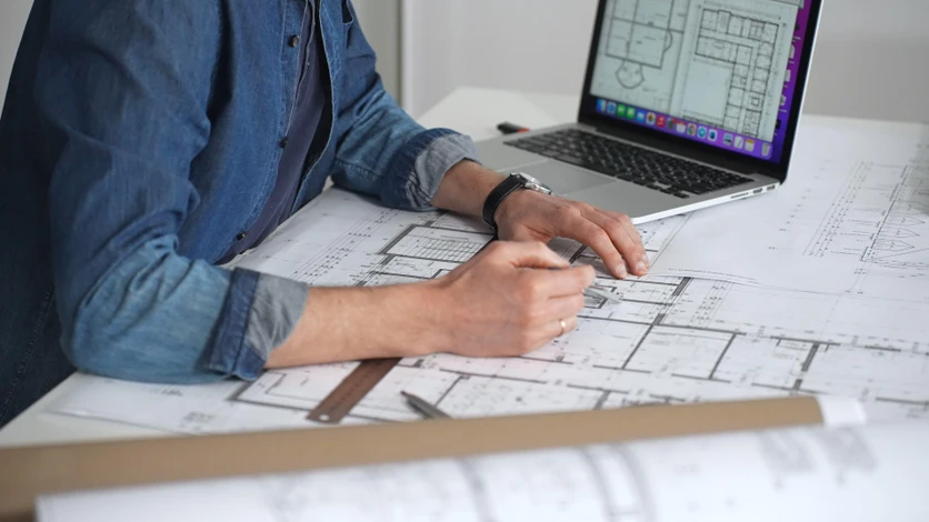 Architecte ou designer travaillant sur des plans d'aménagement dans un bureau moderne